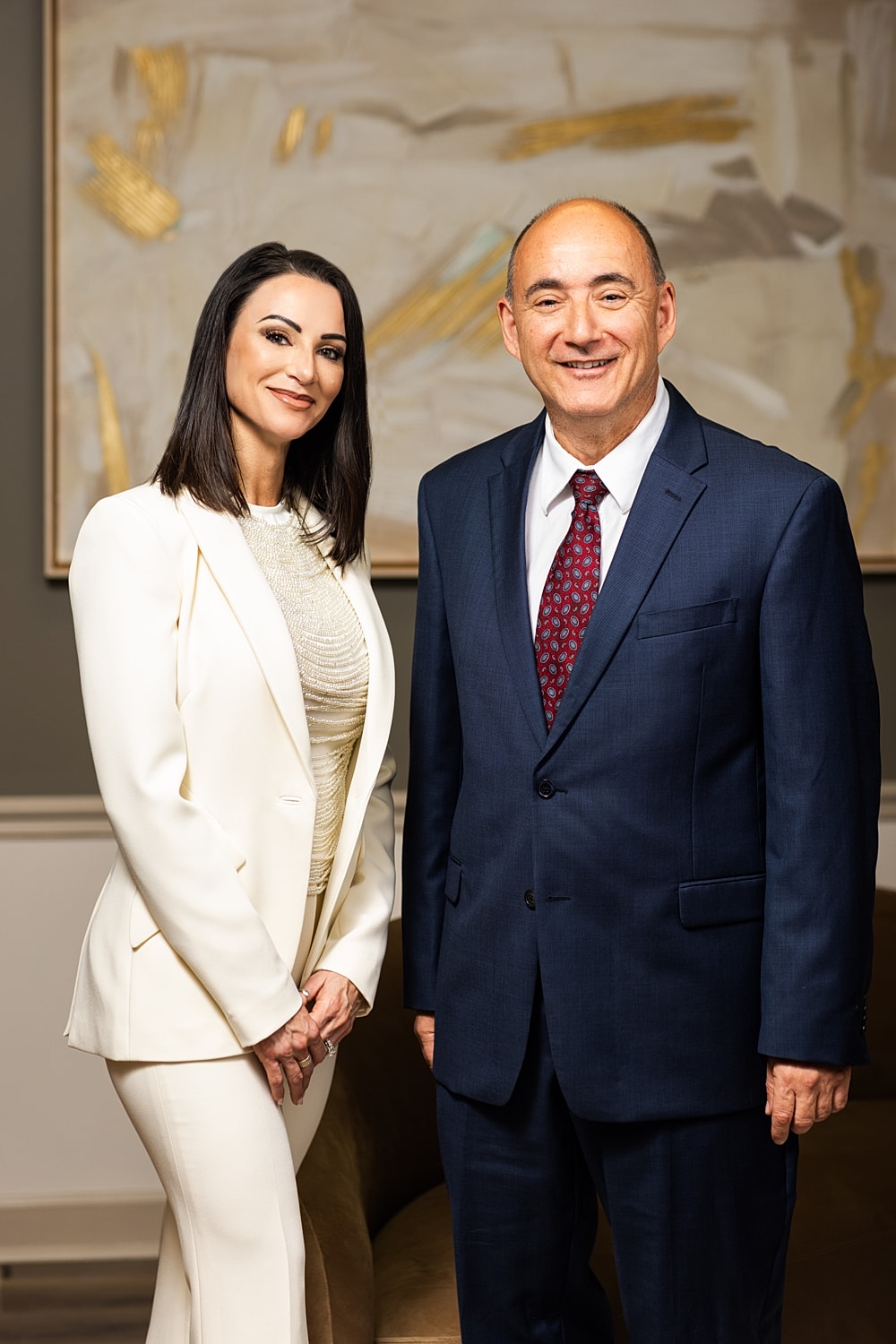 Two professionals posing in formal attire.